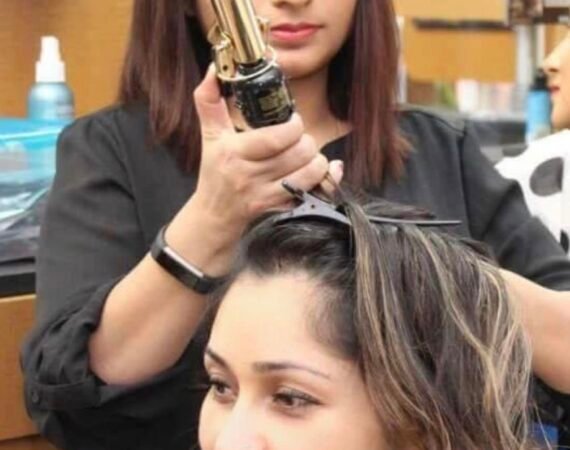 lady straightening another lady's hair