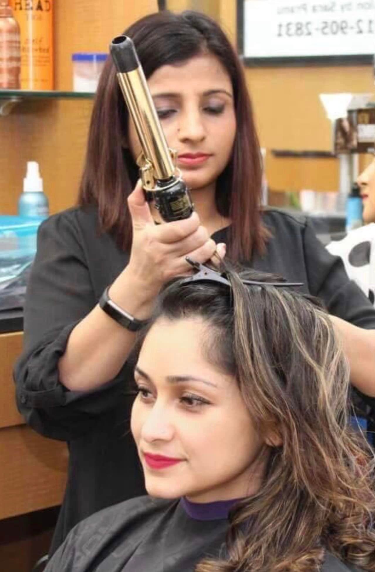 lady straightening another lady's hair